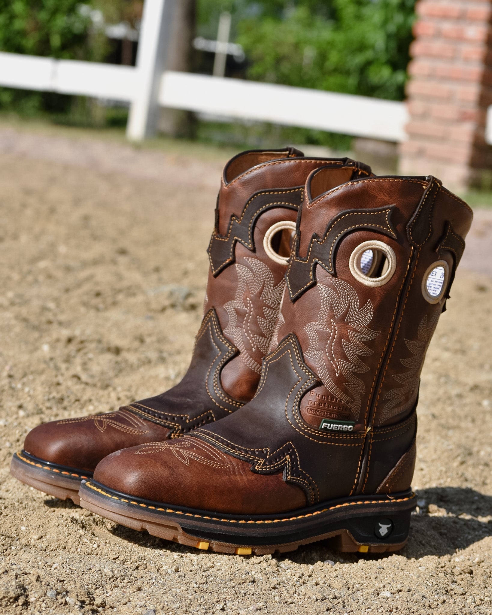 Pair of brown Fuerbo 5038 square-toe rodeo work boots standing on gravel outdoors, showing the front and side profiles.